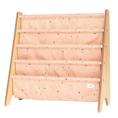 a pink and gold baby crib with polka dots on the bottom, along with wooden legs