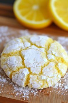 a close up of a doughnut on a cutting board with lemons in the background