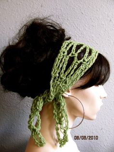 a close up of a mannequin head wearing a green crochet scarf