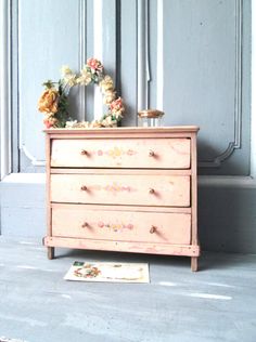 an old dresser with flowers on top