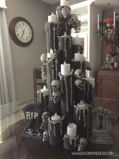 a christmas tree made out of candles and skulls is shown in the middle of a living room