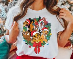 a woman wearing a christmas t - shirt with the image of pooh and friends on it