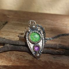 This beautiful purple and green pendant is completely handmade. It is set in lightly oxidised sterling silver and made with natural gemstones, including Amethyst and Serpentine. It is a unique, one of a kind piece. *A chain is available in a separate listing in my shop, please check the link below.  MATERIALS & SIZE: Stone: Serpentine, Amethyst Metal: Sterling Silver and Fine Silver Pendant size: 33mm by 15mm * If you would like to purchase a chain to go with the pendant, here is a link for the Spiritual Green Sterling Silver Jewelry, Fusion Style May Birthstone Jewelry Gift, May Birthstone Fusion Style Gift Jewelry, Fusion Style Jewelry With May Birthstone For Gift, Bohemian Sterling Silver Gemstone Necklaces, Green Gemstone Flower Pendant Jewelry, Bohemian Sterling Silver Gemstone Necklace, Green Pendant Fusion Jewelry, Green Fusion Pendant Jewelry