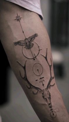 a tattoo on the leg of a person with a deer skull and an arrow in it