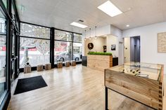 the inside of an office building with wood floors and glass walls, looking out onto the street