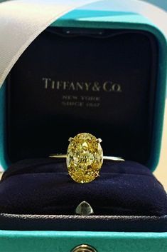 a fancy yellow diamond ring in a blue box