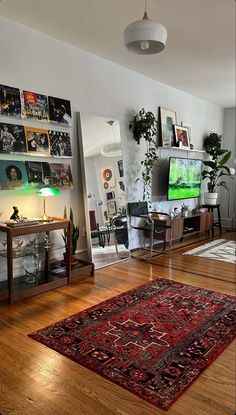 a living room filled with furniture and a flat screen tv mounted on a wall above a wooden floor