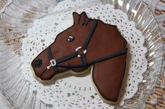 a decorated cookie shaped like a horse on a doily