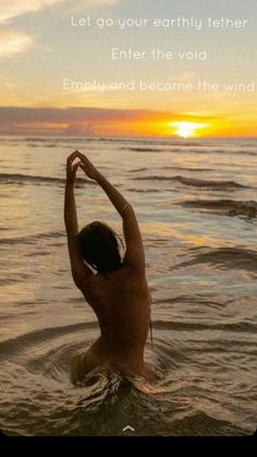 a person standing in the water with their arms above their head and hand up to the sky