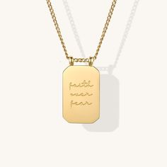 a gold dog tag necklace with the words put your fear on it, hanging from a chain