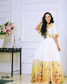 Step into the spotlight with this stunning yellow Habesha wedding outfit, meticulously designed to embody the beauty and cultural richness of Ethiopian traditions for both the bride and groom. Material Cotton Menen Thread Estimated delivery : 2 weeks to 3 weeks Contact WhatsApp +1(304)-306-2784Email: contact@ethiopian.store White Anarkali Dress With Gold Embroidery, Festive White Gown With Gold Embroidery, White Gown For Diwali Traditional Ceremonies, Yellow Floor-length Sets With Dabka Work, Gold Dresses For Traditional Festivals, Gold Dresses For Traditional Ceremonies And Festivals, Traditional Gold Gown With Dabka Details, Gold Gown With Pallu For Traditional Ceremonies, Traditional Drape Yellow Dress For Eid