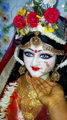 a close up of a person with makeup and flowers on their head wearing a costume