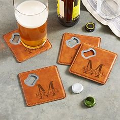 three leather coasters with beer and bottle opener on the table next to it,