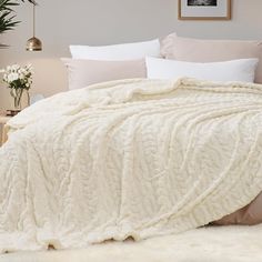 a white blanket is draped over a bed