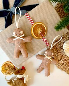 two gingerbread men ornament hanging from twine with orange slices and candy cane