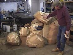 a man standing next to stacks of boxes in a garage