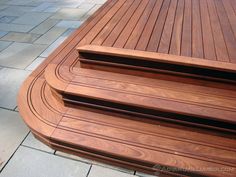 a wooden bench sitting on top of a stone walkway