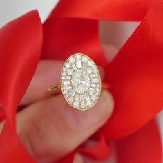 a woman's hand holding a diamond ring with a red ribbon around it,