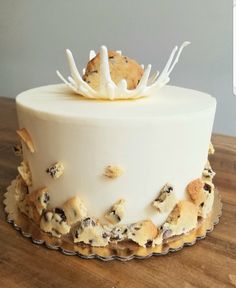 a white cake with cookies and cream frosting on top sitting on a wooden table