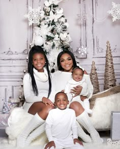 the family is posing in front of a christmas tree