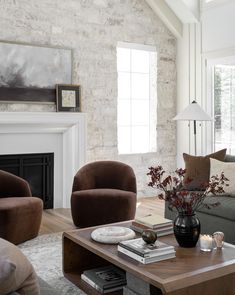 a living room with couches, chairs and a table in front of a fireplace