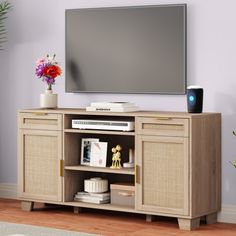 a flat screen tv sitting on top of a wooden entertainment center in a living room