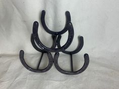 three black iron hooks on a white background