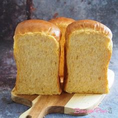 two loaves of bread sitting on top of a cutting board