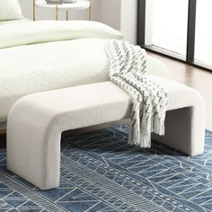 a white bed sitting on top of a blue rug