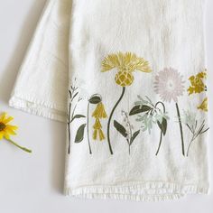 a white towel with yellow and green flowers on it