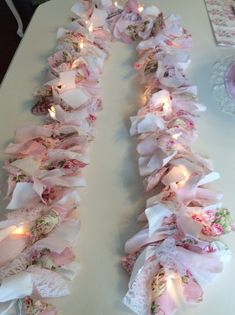 the table is covered in pink and white fabric with candles lit up on each side