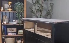 an office desk with drawers and shelves in the corner next to a potted plant