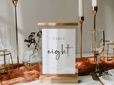 a table setting with candles, wine glasses and a sign that says'table segth '