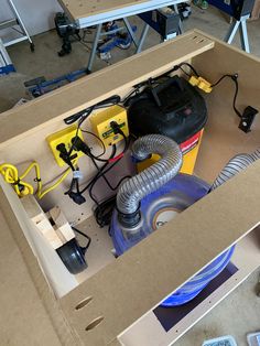 an open box with various tools in it on top of a table next to other items