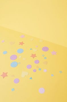 confetti on yellow background with pink and blue confetti scattered around it