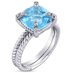 a blue topazte and diamond ring with roped shants on the sides