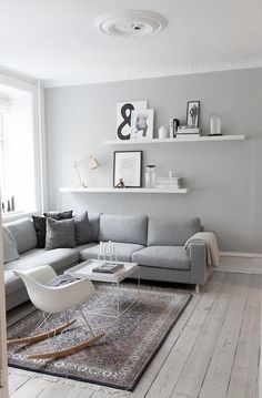 a living room with white walls and grey furniture on the bottom right hand corner is an instagram post