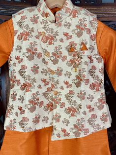 Boys Kurta Pajama Set with Jacket in Floral Weave Work. Item : Boys Kurta Pajama Ready to Wear : Yes Kurta Color : Orange with Light Gold Jacket with floral Pattern Pajama Color : Light Gold Fabric : Silk Pocket : Yes Lining : Yes Disclaimer- There can be little variation in the color due to screen resolution setting, phone display setting or anything else. Kindly do not hold us responsible. Festive Straight Kurta Set With Floral Print, Festive Floral Print Straight Kurta Set, Festive Floral Print Sets For Festivals, Traditional Floral Print Sets For Festivals, Traditional Floral Print Pant Set For Eid, Designer Sets With Printed Motifs For Diwali, Designer Wear Sets With Printed Motifs For Diwali, Traditional Floral Print Sets For Navratri, Designer Floral Print Sets For Festivals