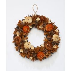 a wreath with leaves and acorns hanging on a wall