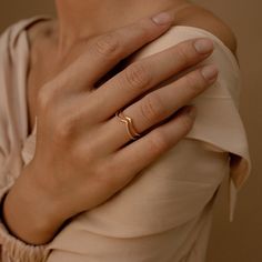 a woman wearing a gold ring with a thin band