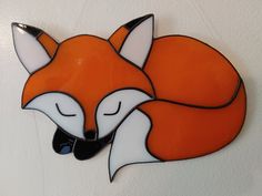 a red fox sleeping on top of a white wall