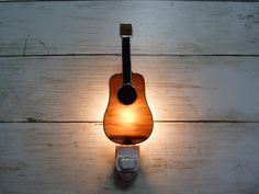 a guitar shaped wall light on a white wood floor with a dimmer in the middle