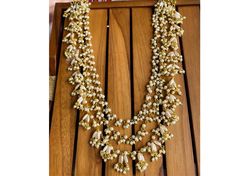 Elevate your look with this stunning 3-layer Rani Haar style pearl necklace, featuring delicate rice pearls, small gold stones, and beads. Perfect for adding elegance to any occasion, this very long pearl necklace is a timeless Indian jewelry piece. Ideal for those seeking a classic long pearl strand. Necklace Only Necklace Has Been Adjustable Cord Gold Tone , Pearl , Stone , Beads Gold Pearl Chain Necklace Choker Women Pearl *SHOP LINK - https://www.etsy.com/shop/ColourstoneWorld?ref=profile_he Wedding Multi-strand Pearl Drop Necklace, Wedding Multi-strand Pearl Necklace With Pearl Drop, Gold Pearl Necklace With Dangling Beads For Wedding, Wedding Gold Pearl Necklace With Dangling Beads, Wedding Pearl Necklace With Multi-strand Pearl Chain, Gold Bridal Necklace With Dangling Beads For Wedding, White Pearl Chain Necklace For Receptions, Multi-strand Pearl Beaded Necklace For Wedding, Gold Bridal Necklace With Round Beads For Reception