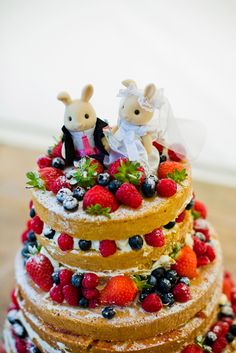 a wedding cake with strawberries and blueberries on top