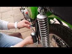 a person is working on a motorbike with springs attached to the front tire