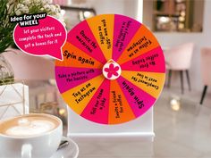 a spinning wheel with words on it next to a cup of coffee