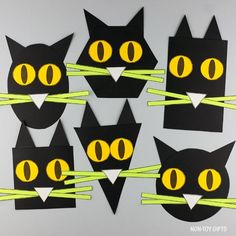 black cats with yellow eyes cut out from construction paper and tied to green sticks in the shape of cat's head