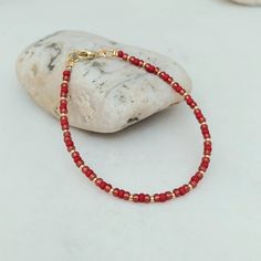 "This delicate berry red and gold bracelet has been lovingly made using 3mm glass Miyuki seed beads. Highlighted with 2mm gold Miyuki seed beads.  The vibrant colours are simply stunning and take your thoughts Christmas. Perfect as a gift or a treat for yourself. Threaded on strong stainless steel 7 strand Tiger Tail wire and finished with gold plated wire guardians, and a trigger clasp and optional extender chain. More Colours and Designs can be found at: https://www.etsy.com/uk/shop/CraftHutCo Red Beaded Dainty Jewelry, Red Dainty Jewelry With Round Beads, Dainty Red Round Bead Jewelry, Red Dainty Round Beaded Jewelry, Dainty Red Round Beaded Jewelry, Red Beaded Friendship Bracelets, Red Crystal Bracelet With Spacer Beads, Dainty Red Beaded Bracelets With Tiny Beads, Hand-strung Red Friendship Bracelets With Round Beads