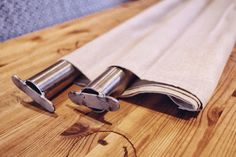 two pieces of cloth sitting on top of a wooden table next to metal scissors and a pair of pliers