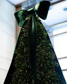 a large christmas tree with a green bow on it